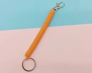 Porte-clés ressort en plastique rétractable orange vif avec mousqueton et anneau en métal.