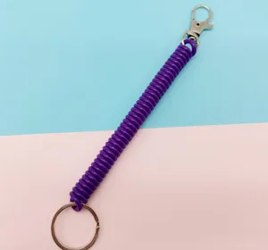 Porte-clés spirale en plastique violet rétractable avec mousqueton et anneau métal.