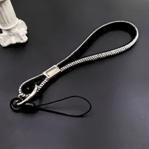 Detailed shot of black rhinestone phone wrist strap with sparkling diamonds and metal connector.