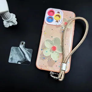 Detailed shot of sparkly rhinestone phone wrist strap, floral phone case and tether tab.