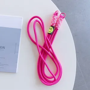 Pink phone lanyard detail showing the durable woven rope and cute yellow smiley charm.