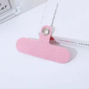 Detalle en primer plano de una lengüeta de cordón para teléfono móvil rosa con ojales metálicos.