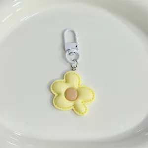 Detailed shot of a cute yellow flower keychain, candy-colored bag charm accessory with clasp.