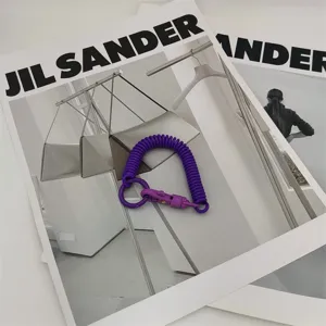 Porte-clés à ressort hélicoïdal violet et pendentif de sac pour accessoire quotidien.