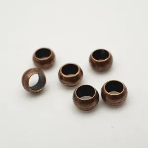 Close-up detail of antique bronze brass crimp beads for DIY jewelry making and beading accessories.