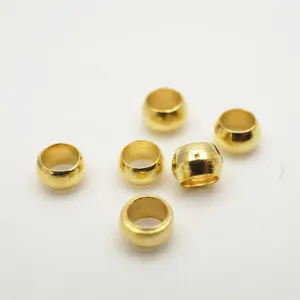 Close-up detail of 2mm gold plated crimp beads for DIY jewelry making and crafting ends.