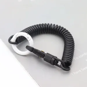 Gros plan détaillé d'un porte-clés cordon à ressort noir équipé d'un mousqueton rond blanc.