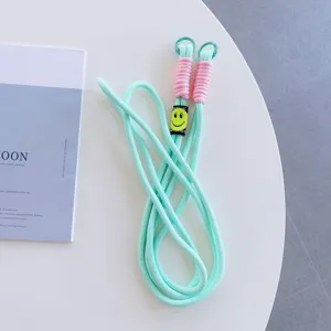 Mint green phone lanyard cross-body strap with pink wrapped ends and cute smiley face decor.