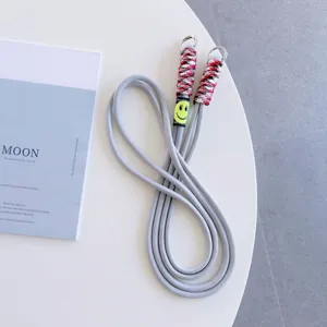 Gray phone lanyard strap with colorful woven accent and cute smiley face charm for crossbody use.