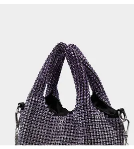 Détail de sac à main en strass violet, sac seau en cristal scintillant avec poignées.