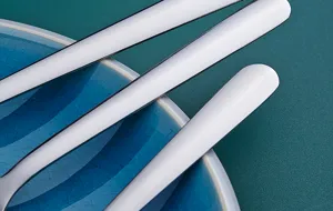 Primer plano detallado de cucharas de acero inoxidable sobre un plato ceramico azul.