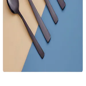 Dettaglio di posate in acciaio inossidabile nero opaco, elegante design con manico quadrato.