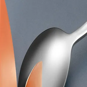 Détail de cuillère en acier inoxydable, gros plan sur la texture du métal polie.