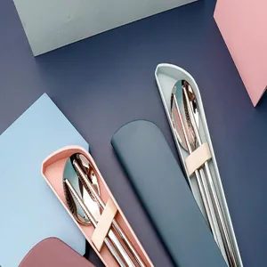 Détail des couverts de voyage en acier inoxydable avec baguettes et cuillère dans un étui.