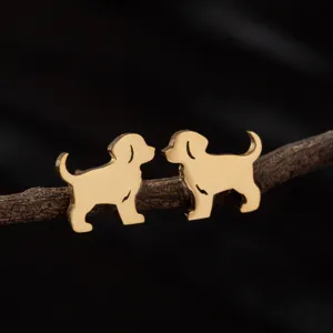 Primer plano detallado de simpáticos pendientes de tuerca de perro en acero dorado.