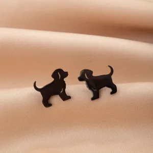 Primer plano de pendientes de tuerca de cachorro negro, detalle de acero inoxidable.