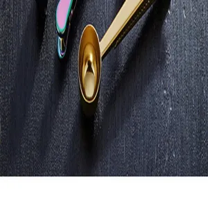 Stainless steel coffee scoop with sealing clip detail, golden finish, precision baking tool.