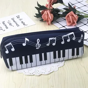 Vista detallada de un estuche cuadrado azul oscuro con estampado de teclas de piano y notas.