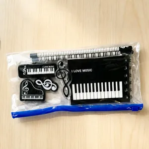 Close-up detail of music theme stationery set with notebook, pencils and erasers in pouch.