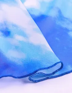 Detailansicht von Chiffonstoff mit blauem Himmel und Wolkenprint und feiner Kantennaht.
