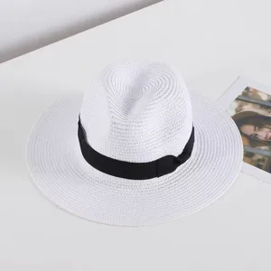 Detalle de sombrero fedora de paja blanca con cinta negra clásica para proteccion solar.
