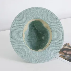 Vista detallada de un sombrero de paja de verano azul claro, con textura tejida y banda interna.