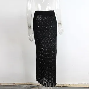 Detalle de falda larga negra de punto calado, pareo de playa sexy de talle alto.