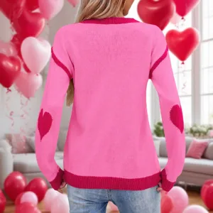 Dettaglio maglione lavorato a maglia rosa San Valentino con toppe a cuore sui gomiti e girocollo.