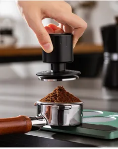 Coffee tamper detail view showing stainless steel base and adjustable pressure mechanism.