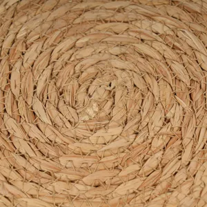 Close up view of hand woven straw placemat showing detailed natural texture and design.