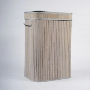 Gros plan sur la texture de la corbeille à linge en bambou tissé avec bordure en tissu gris.