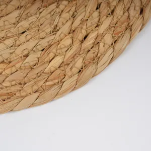 Handwoven straw placemat detail, natural cattail rope heat insulation pad for dining table decor.