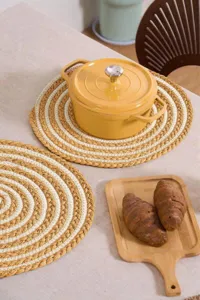 Handmade round placemat braided with raffia and cotton rope, heat-resistant table mat detail.