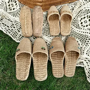 Handmade straw slippers detail shot, natural woven texture on lace and grass background.