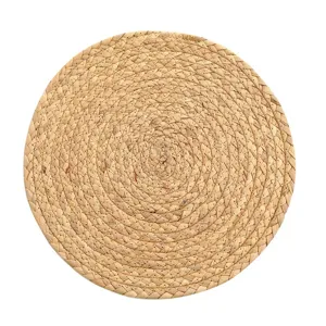 Handmade natural woven straw placemat detail, round heat insulation coaster closeup view.