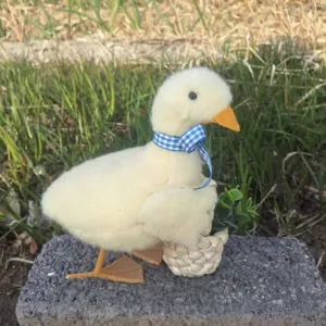 Charmante figurine de canard en peluche avec ruban à carreaux bleus pour la décoration.