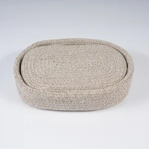 Closeup detail view of the oval woven cotton rope storage basket with matching lid texture.