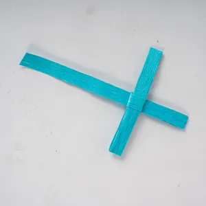 Primer plano detallado de una cruz tejida azul hecha a mano, mostrando textura y artesanía.
