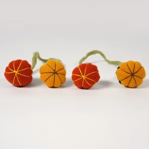 Handmade felt pumpkin napkin rings detailed close up view for Halloween autumn party decor.