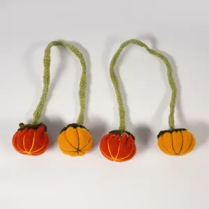 Handmade felt pumpkin napkin rings and Halloween decor details, soft fabric and green stems.