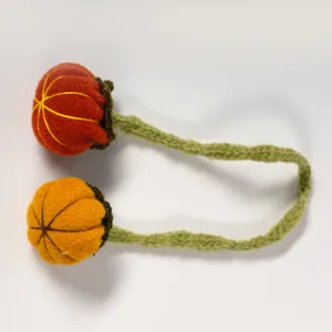 Detailed view of handmade knitted pumpkin napkin ring craft accessory for Halloween decor.