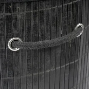 Black bamboo laundry basket detail view featuring woven slats, sturdy rope handles and metal eyelets.