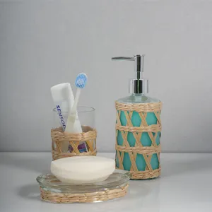 Detailed view of handmade straw woven glass bathroom soap dispenser and cup set closeup.