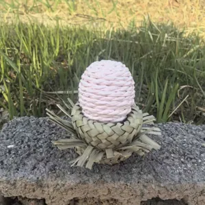 Détail du nid d'oiseau en paille tressée, base naturelle avec boule en corde de papier.