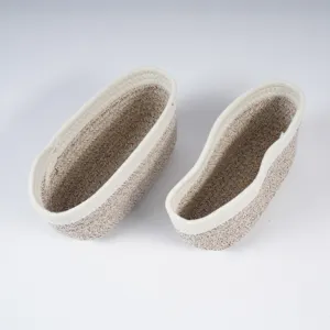 Detail view of woven cotton rope storage baskets, stylish oval design for home organization.