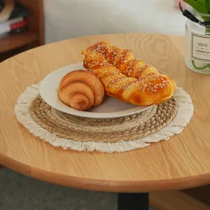 Round straw woven placemat with tassel edge, natural texture heat-insulating table mat detail view.