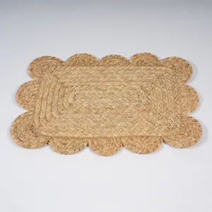 Détail en gros plan d'un set de table en paille tressée avec bordure festonnée style rustique.