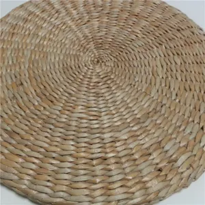 Close-up detail of hand-woven natural straw meditation cushion, showing fine texture.