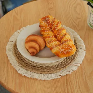 Woven straw placemat with fringe for dining table, rustic heat-insulating kitchen mat.