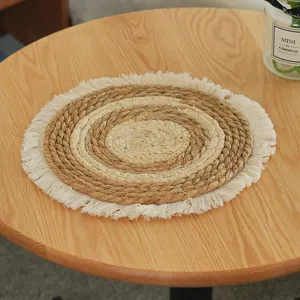 Handmade woven straw placemat detail, round heat resistant coaster with white fringe decor.